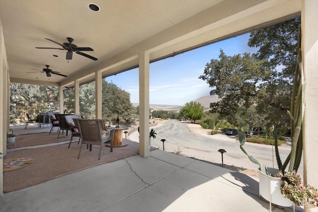 view of patio featuring ceiling fan and a mountain view