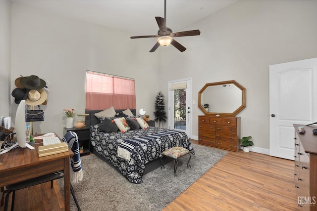 bedroom with ceiling fan, light hardwood / wood-style flooring, and high vaulted ceiling