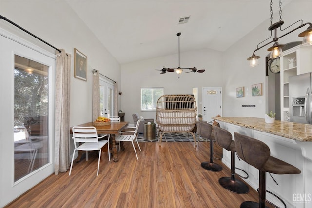 dining room with ceiling fan, dark hardwood / wood-style flooring, and lofted ceiling