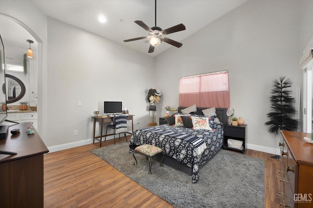 bedroom with ceiling fan, high vaulted ceiling, and hardwood / wood-style flooring