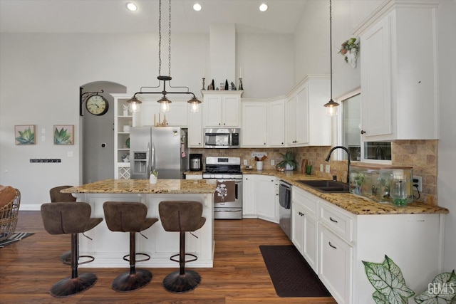 kitchen featuring a center island, hanging light fixtures, sink, appliances with stainless steel finishes, and white cabinetry