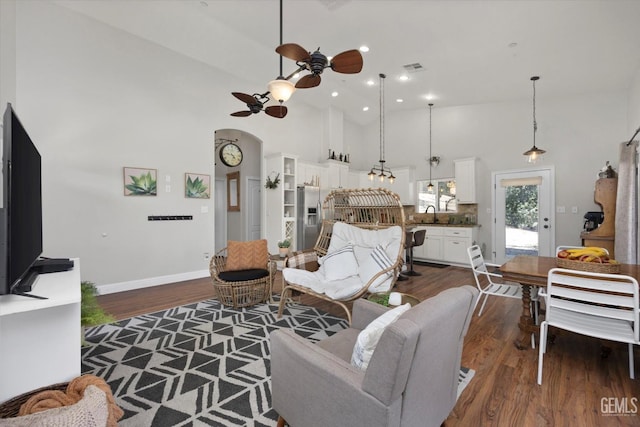 living room with ceiling fan, sink, high vaulted ceiling, and dark hardwood / wood-style floors