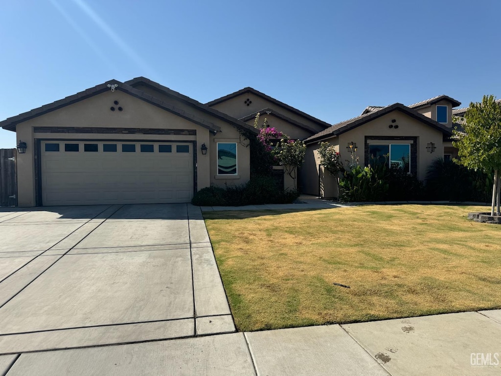 ranch-style house featuring stucco siding, driveway, a garage, and a front yard