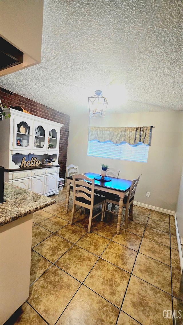 dining area featuring tile patterned flooring and a textured ceiling