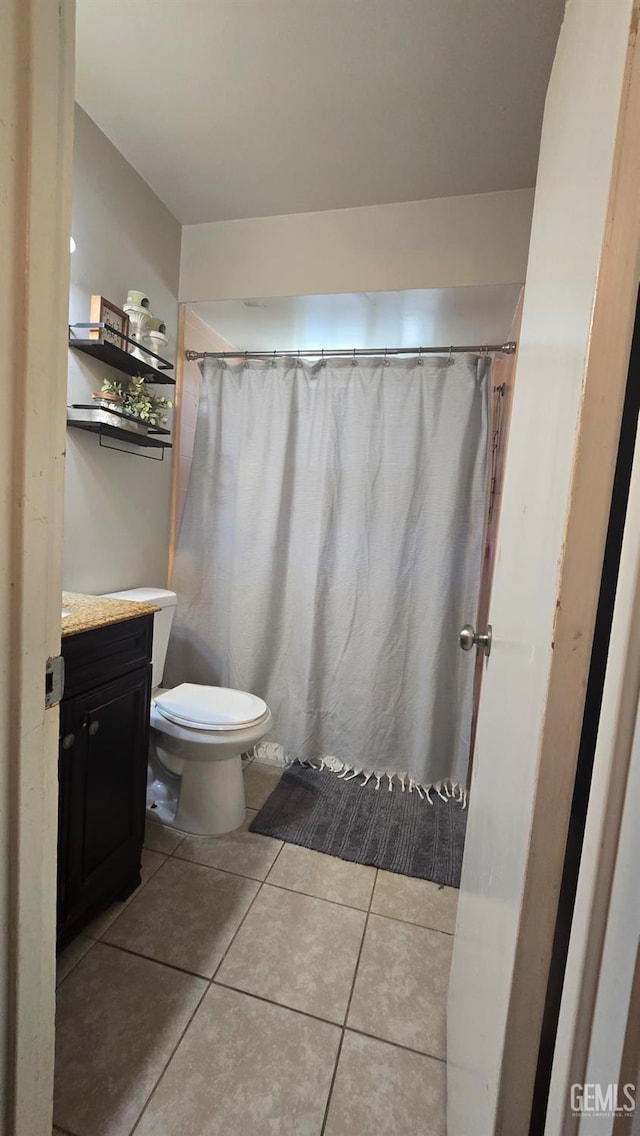 bathroom with tile patterned flooring, vanity, and toilet