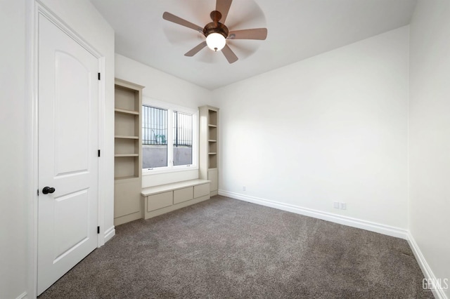 unfurnished bedroom with dark colored carpet and ceiling fan