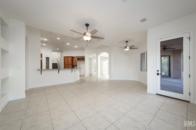 unfurnished living room featuring light tile patterned floors and ceiling fan