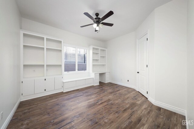 unfurnished living room with ceiling fan and dark wood-type flooring