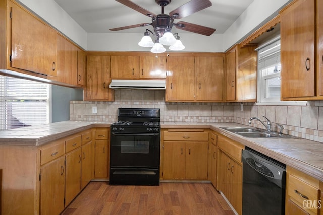 1909 Carrere St, Bakersfield, CA 93308 - kitchen featuring ceiling fan, under cabinet range hood, tile countertops, a sink, and black appliances