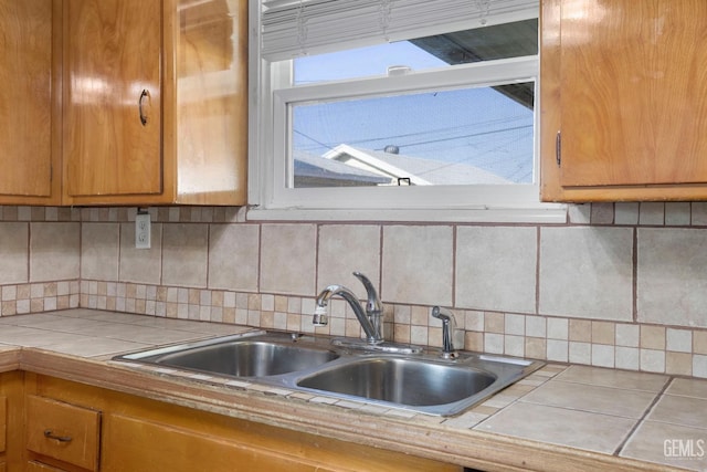 1909 Carrere St, Bakersfield, CA 93308 - kitchen featuring decorative backsplash, a sink, tile counters, and brown cabinets