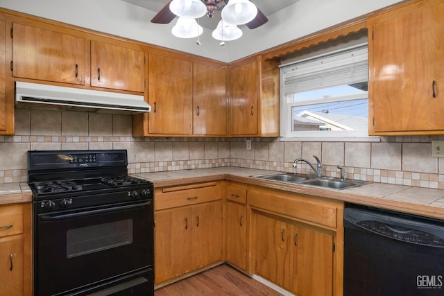 1909 Carrere St, Bakersfield, CA 93308 - kitchen featuring a sink, under cabinet range hood, tile countertops, black appliances, and ceiling fan