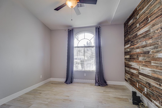 6800 Eagle Cap St, Bakersfield, CA 93313 - empty room featuring ceiling fan, light wood-type flooring, an accent wall, and wooden walls