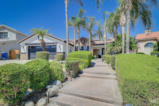 6800 Eagle Cap St, Bakersfield, CA 93313 - view of front of home with roof mounted solar panels, stone siding, driveway, and stucco siding