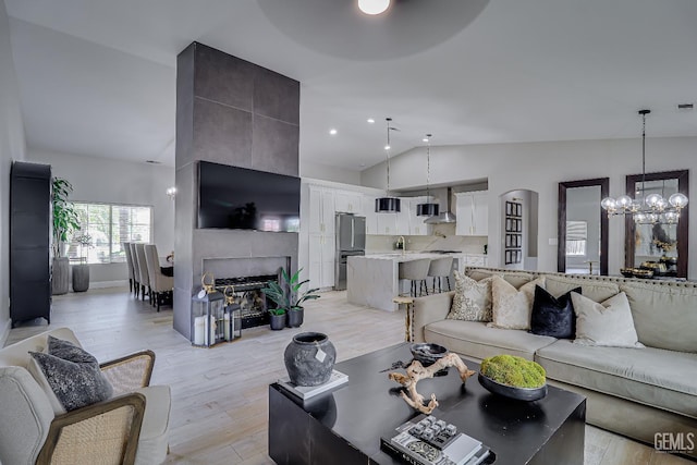 6800 Eagle Cap St, Bakersfield, CA 93313 - living room featuring a chandelier, light wood-style floors, a fireplace, recessed lighting, and high vaulted ceiling