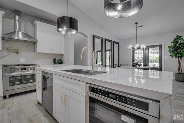 6800 Eagle Cap St, Bakersfield, CA 93313 - kitchen featuring appliances with stainless steel finishes, wall chimney exhaust hood, vaulted ceiling, plenty of natural light, and white cabinets