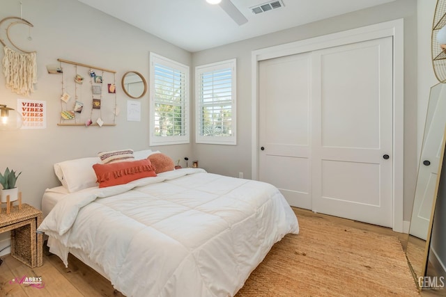 bedroom with ceiling fan, light hardwood / wood-style flooring, and a closet