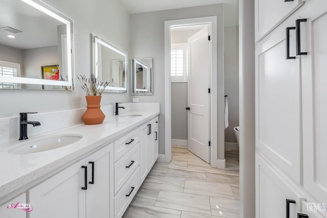 bathroom featuring a wealth of natural light, vanity, and toilet