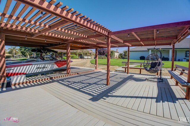 wooden terrace featuring a lawn and a pergola