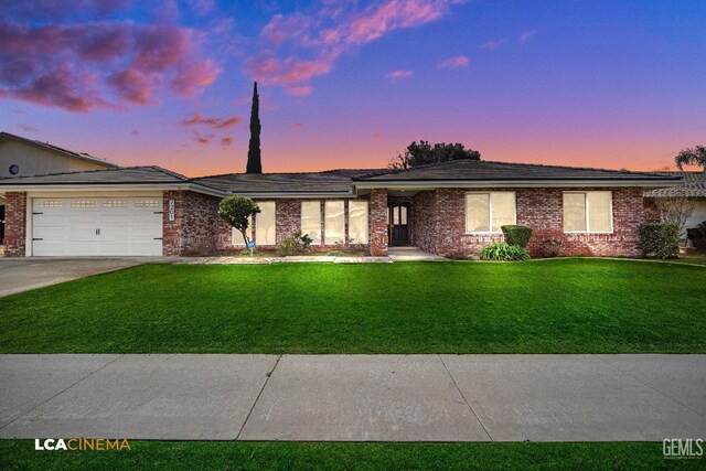 single story home featuring a garage and a front lawn