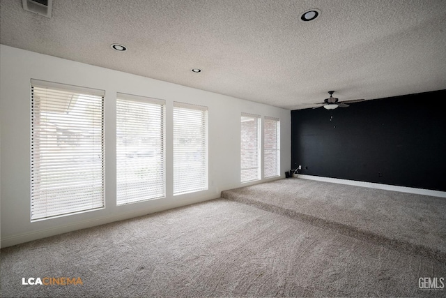 spare room with ceiling fan, a textured ceiling, and carpet