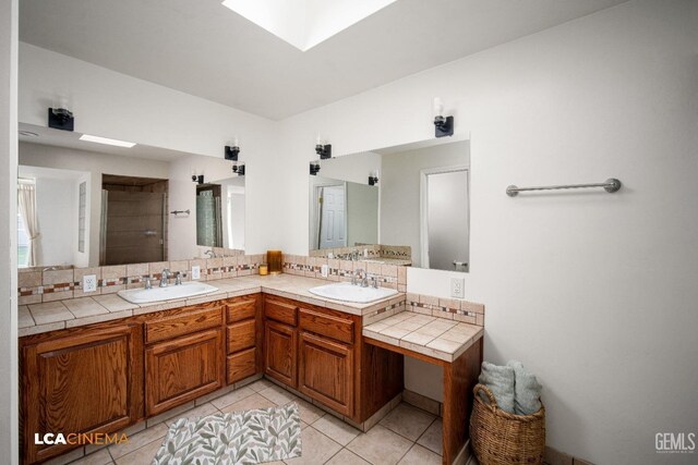 bathroom featuring tasteful backsplash, vanity, a skylight, and tile patterned floors