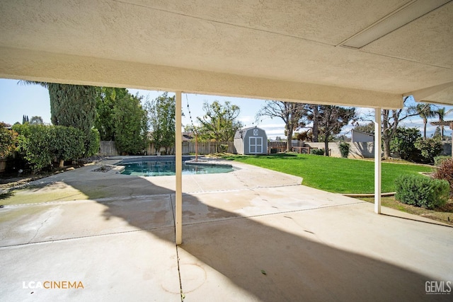 view of swimming pool featuring a storage shed, a lawn, and a patio area