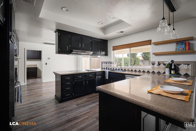 kitchen featuring tasteful backsplash, dark hardwood / wood-style flooring, kitchen peninsula, a raised ceiling, and black electric stovetop