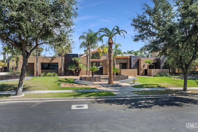 southwest-style home with a front lawn