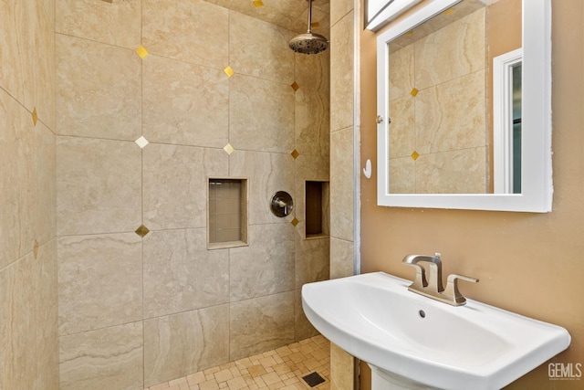 bathroom with a tile shower and sink