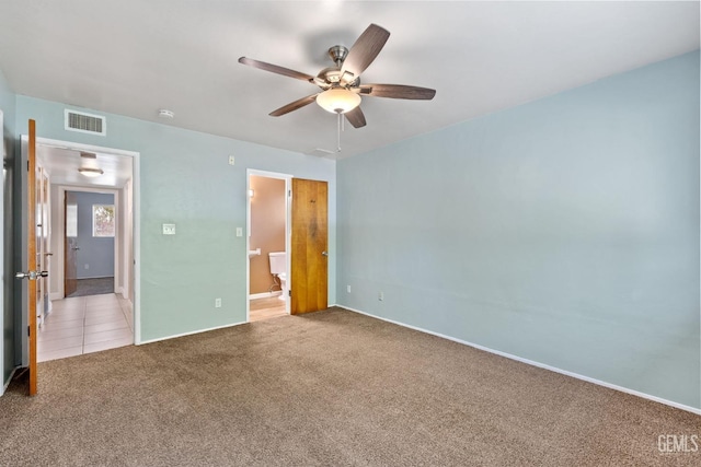 unfurnished bedroom with carpet flooring, ceiling fan, and ensuite bath