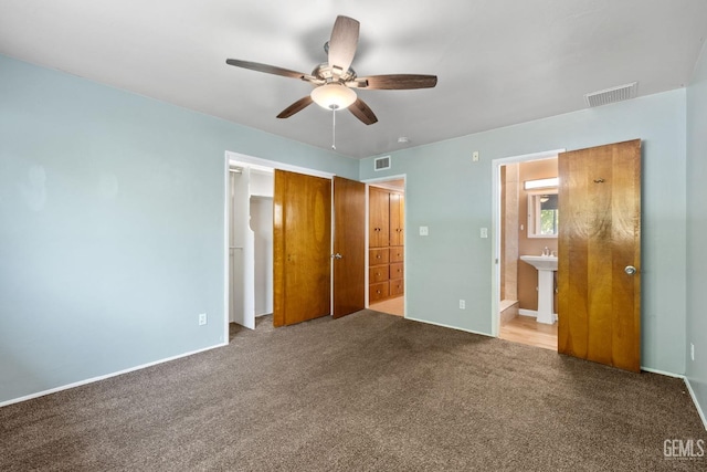 unfurnished bedroom featuring connected bathroom, ceiling fan, a closet, and carpet floors