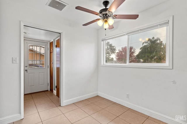 empty room featuring ceiling fan and light tile patterned flooring