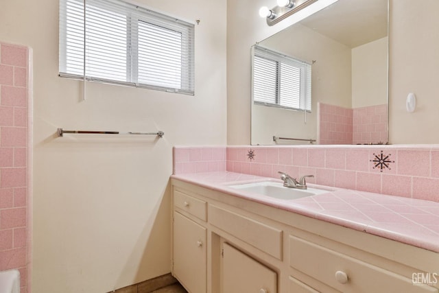 bathroom with vanity, a tub to relax in, and tasteful backsplash