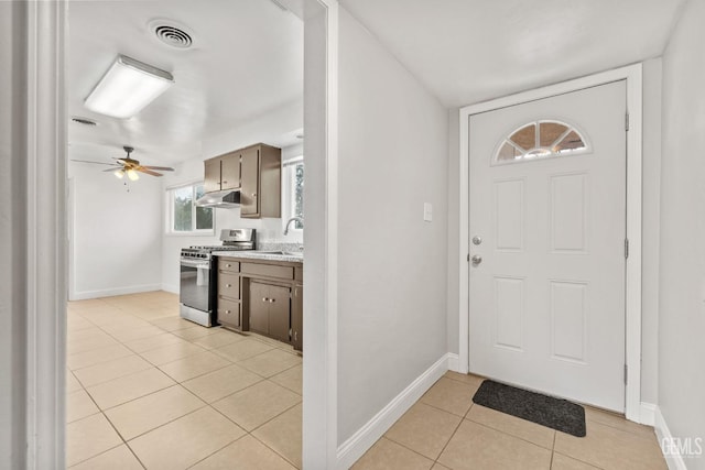 entrance foyer featuring ceiling fan, sink, and light tile patterned floors