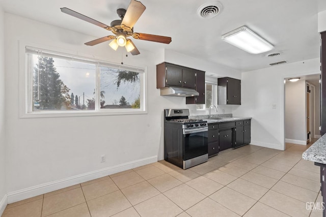 kitchen featuring light tile patterned floors, gas stove, ceiling fan, and sink