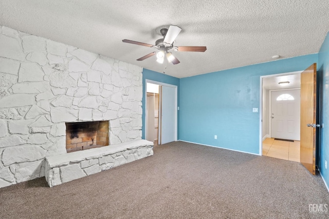 unfurnished living room with a fireplace, light colored carpet, and a textured ceiling