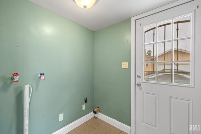 clothes washing area featuring hookup for an electric dryer and light tile patterned flooring