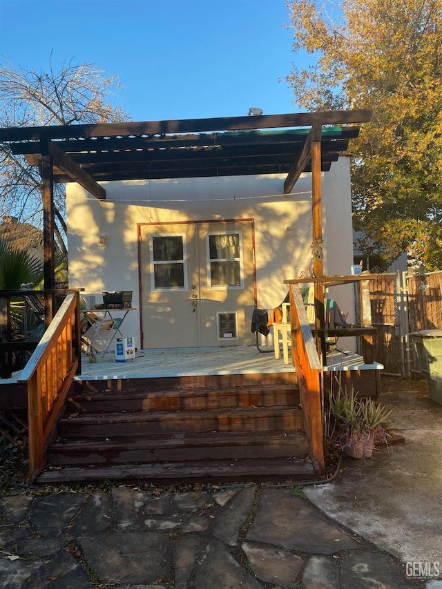 back of property with a pergola and a deck