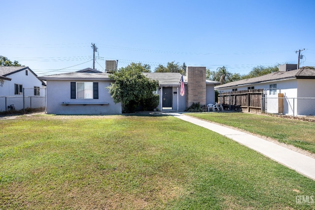 view of front of house with central AC unit and a front yard