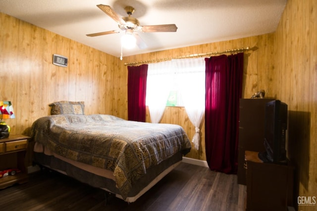 bedroom with wooden walls, a ceiling fan, and wood finished floors