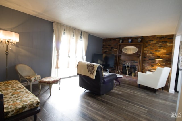 living area featuring a textured ceiling, dark wood finished floors, and a fireplace
