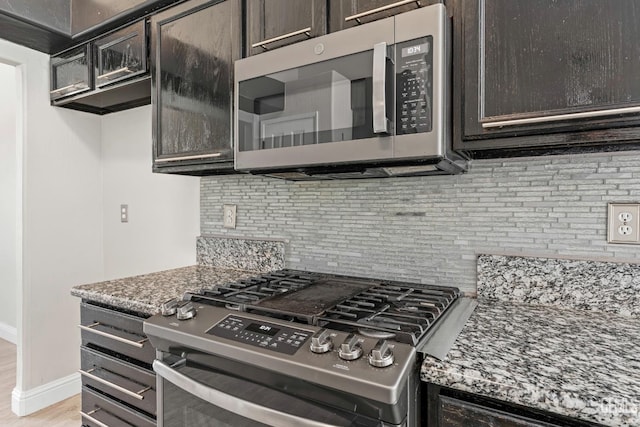 12017 Hannah Denise Ave, Bakersfield, CA 93312 - kitchen with appliances with stainless steel finishes, dark brown cabinets, backsplash, and light stone counters