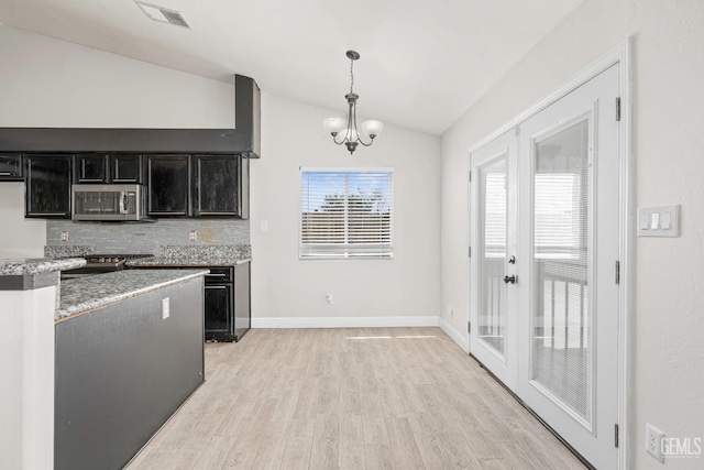 12017 Hannah Denise Ave, Bakersfield, CA 93312 - kitchen featuring stainless steel microwave, vaulted ceiling, dark cabinets, light wood-style floors, and decorative backsplash