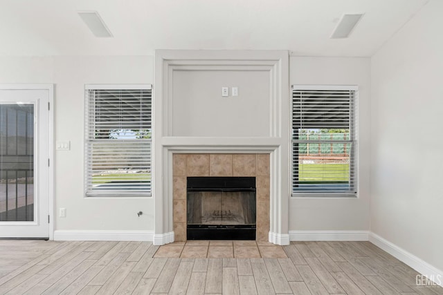 12017 Hannah Denise Ave, Bakersfield, CA 93312 - unfurnished living room with light wood-style floors and a tile fireplace