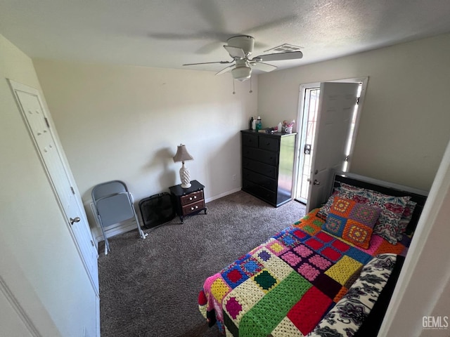 bedroom with dark colored carpet, ceiling fan, and a textured ceiling