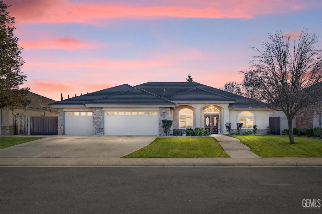 view of front facade with a garage and a lawn