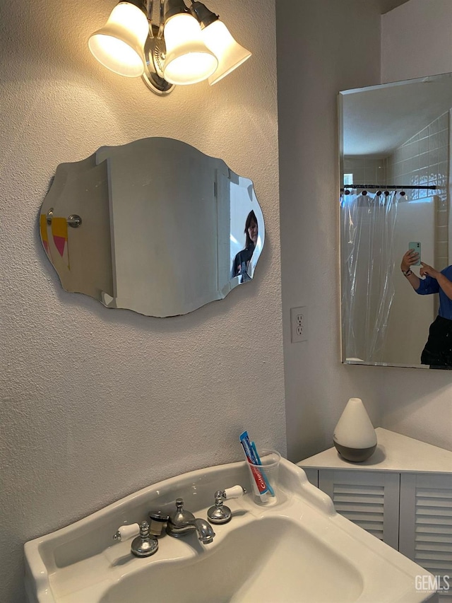 bathroom featuring a sink and curtained shower