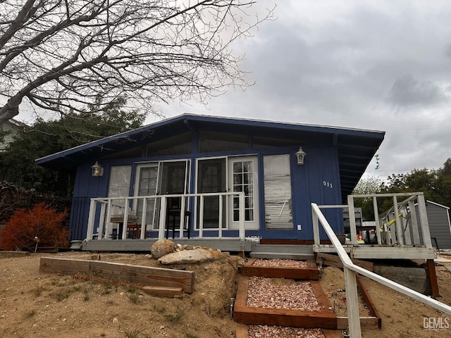 rear view of property with a deck and a sunroom