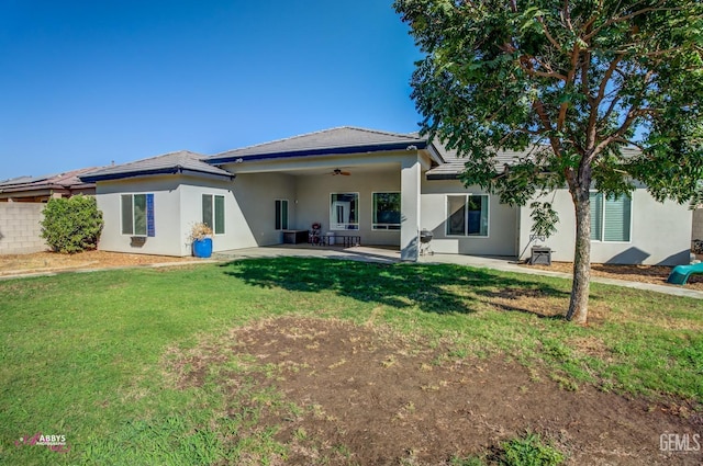 back of house featuring ceiling fan, a yard, and a patio