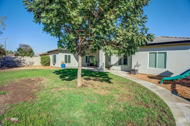 rear view of property featuring a yard and a patio